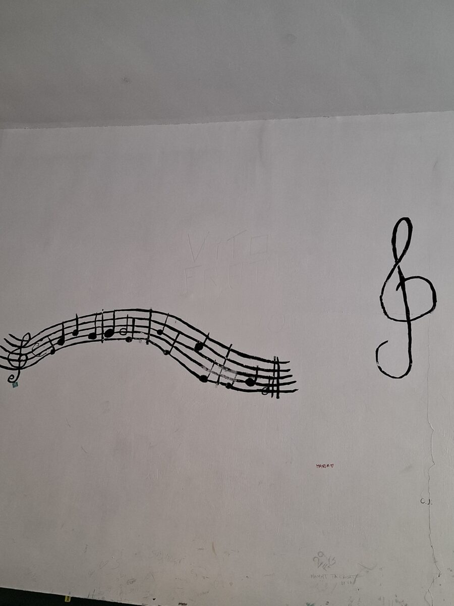 Pentagramma e chiave di violino dipinti su una parete della scuola